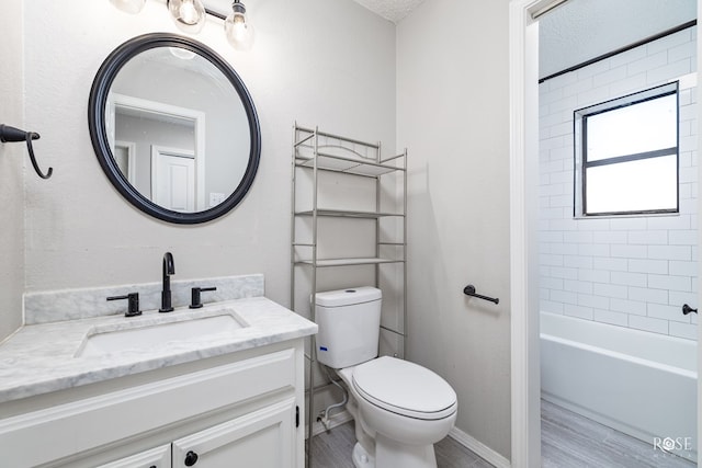 full bathroom with vanity, hardwood / wood-style floors, tiled shower / bath combo, and toilet