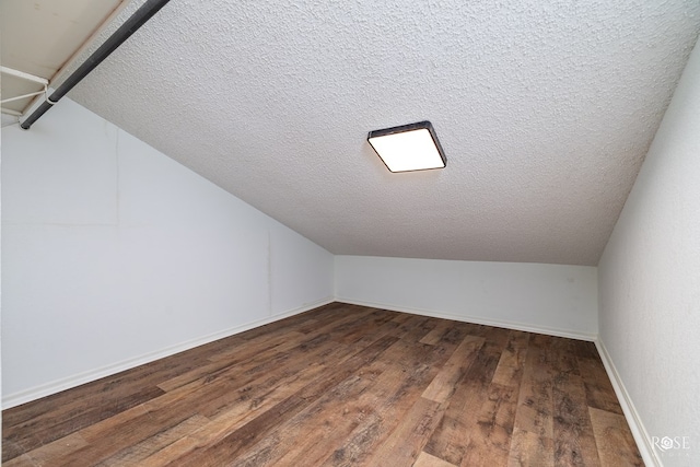 additional living space featuring hardwood / wood-style flooring and vaulted ceiling