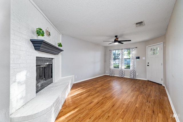 unfurnished living room with ceiling fan, hardwood / wood-style flooring, and a textured ceiling