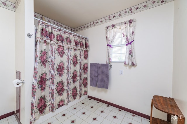 full bathroom featuring tile patterned floors, a shower with curtain, and baseboards