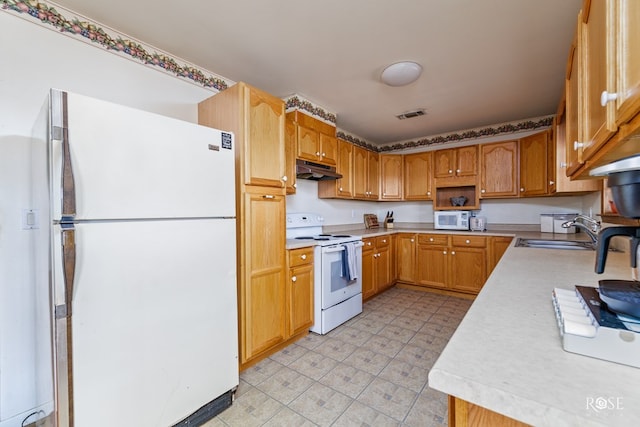 kitchen featuring white appliances, visible vents, a sink, light countertops, and under cabinet range hood