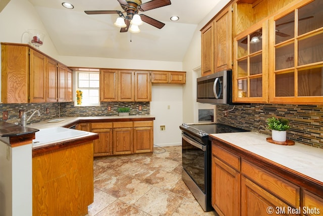 kitchen with brown cabinetry, stainless steel microwave, electric stove, and lofted ceiling