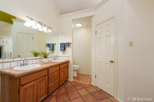 bathroom with tile patterned flooring, double vanity, toilet, and a sink