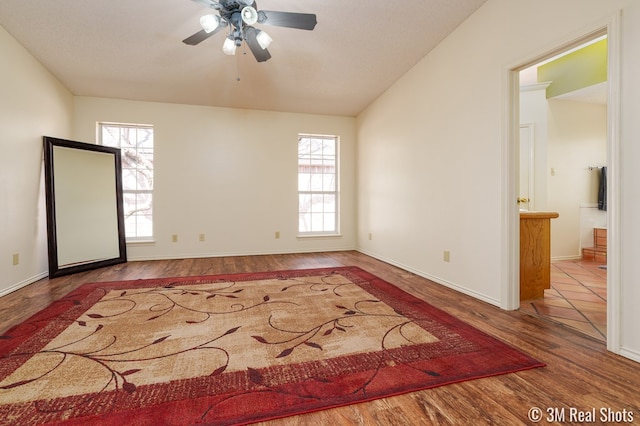 unfurnished room with wood finished floors, baseboards, and ceiling fan