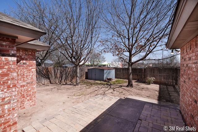 view of patio / terrace featuring a storage unit, an outbuilding, and a fenced backyard