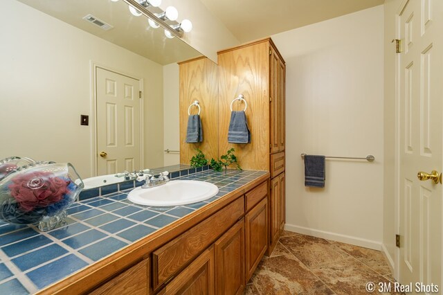 bathroom with visible vents, vanity, and baseboards