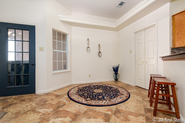 entryway featuring visible vents, stone finish floor, crown molding, and baseboards