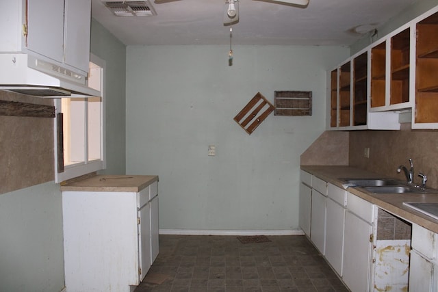 kitchen with white cabinetry, sink, backsplash, and ceiling fan