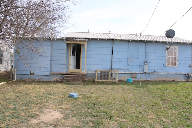 rear view of house featuring a lawn