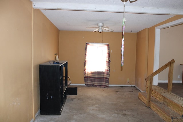 miscellaneous room featuring ceiling fan, concrete floors, and a textured ceiling