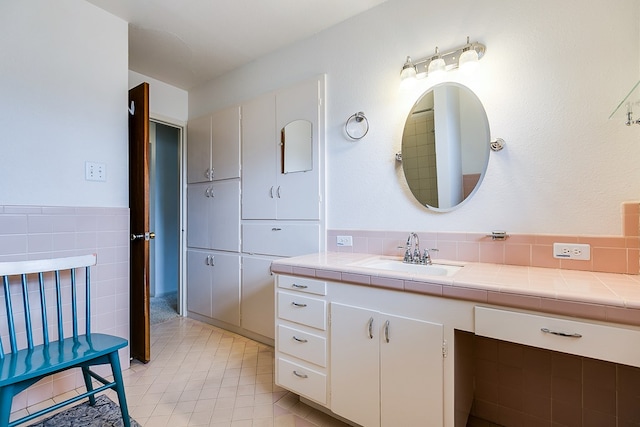 bathroom featuring tile patterned flooring, tile walls, and vanity