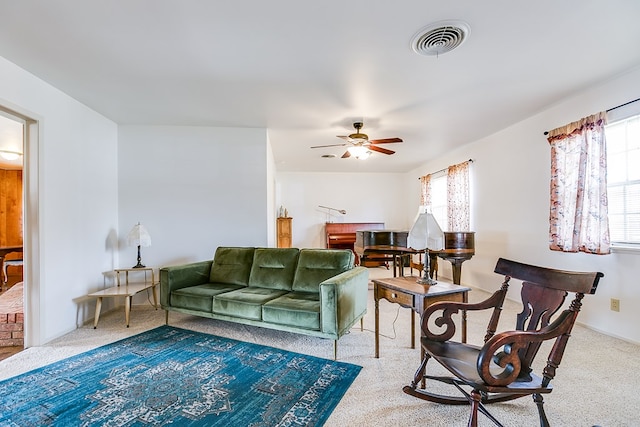 living area with carpet floors, visible vents, and ceiling fan