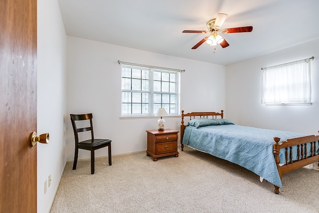 bedroom featuring ceiling fan, multiple windows, and carpet