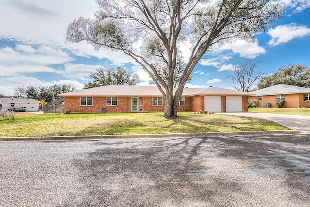 ranch-style home with an attached garage, brick siding, fence, driveway, and a front lawn