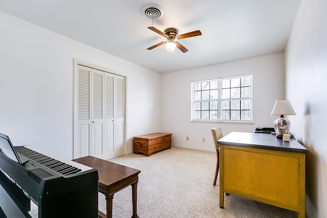 office area with light carpet, visible vents, and a ceiling fan