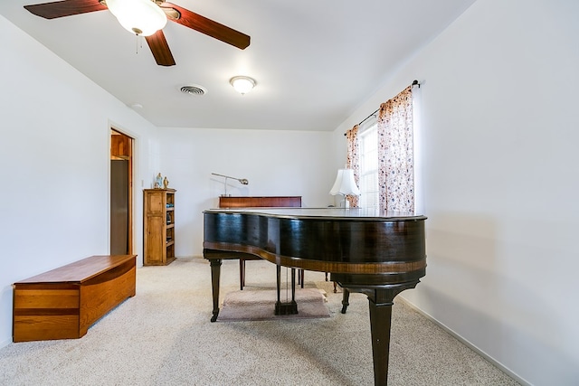 living area with carpet flooring, visible vents, and a ceiling fan