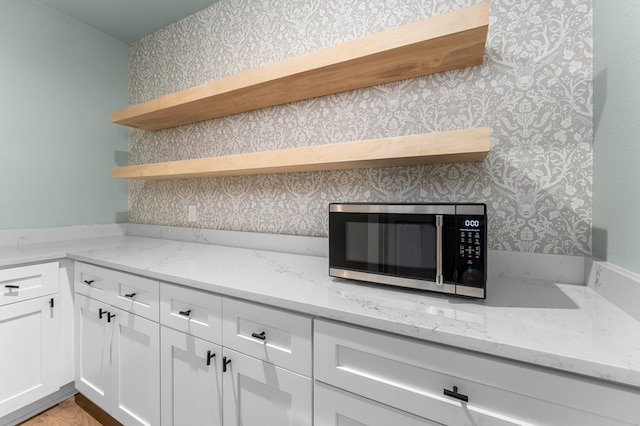 kitchen with light stone counters and white cabinetry