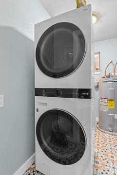 laundry room featuring stacked washer and dryer and water heater