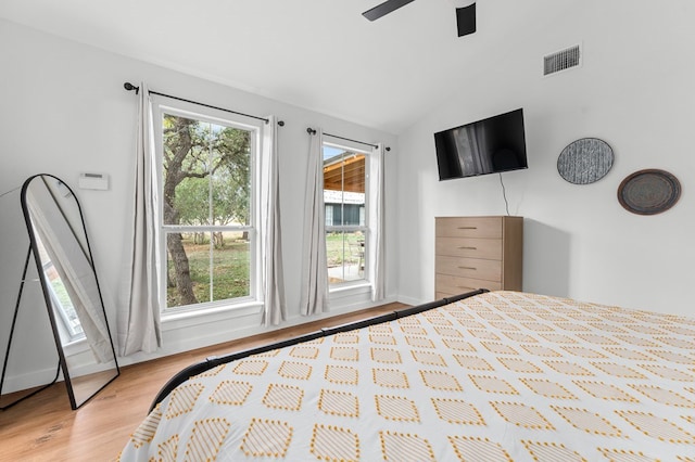 bedroom featuring multiple windows, vaulted ceiling, light hardwood / wood-style floors, and ceiling fan