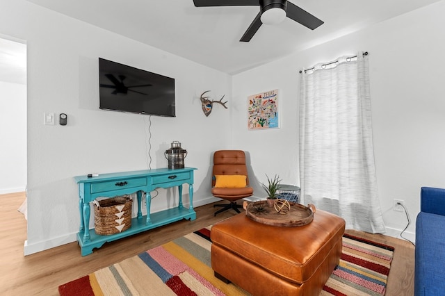 living area featuring hardwood / wood-style flooring and ceiling fan