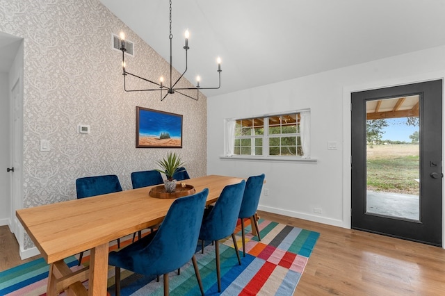 dining space featuring high vaulted ceiling and light hardwood / wood-style flooring