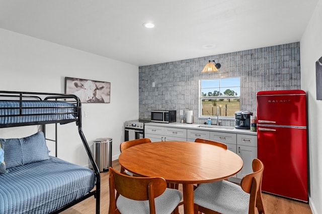 kitchen with sink, fridge, and light wood-type flooring