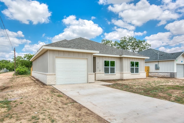 2114 Deaton St, San Angelo, TX 76903 - view of front facade with a shingled roof, concrete driveway, an attached garage, and brick siding