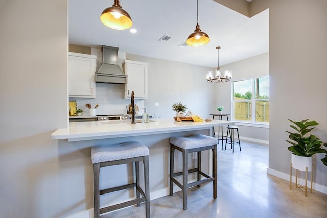 2114 Deaton St, San Angelo, TX 76903 - kitchen featuring premium range hood, backsplash, baseboards, and a breakfast bar