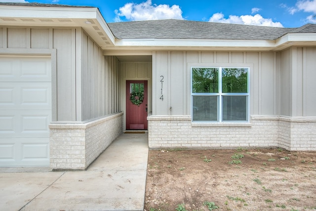 2114 Deaton St, San Angelo, TX 76903 - property entrance featuring an attached garage, board and batten siding, brick siding, and a shingled roof
