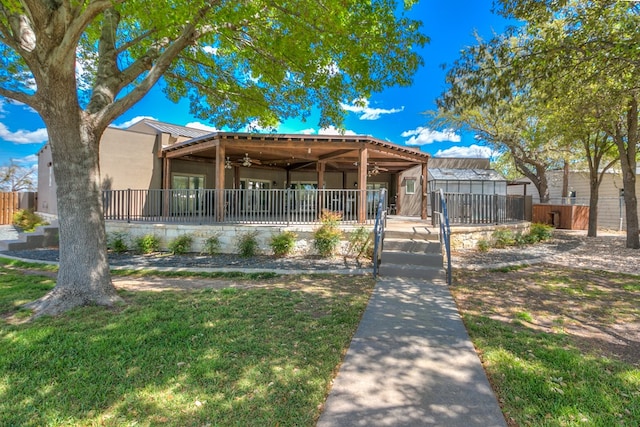 view of front of property with ceiling fan, metal roof, fence private yard, and stucco siding