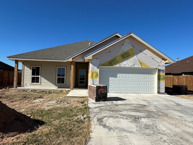 view of front of house featuring a garage and central AC unit