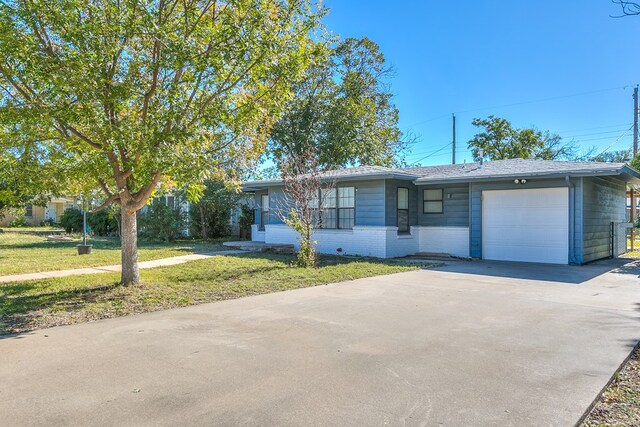 ranch-style house featuring a garage and a front yard