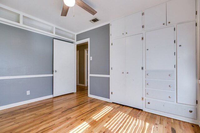 unfurnished bedroom with light hardwood / wood-style flooring, a closet, and ceiling fan