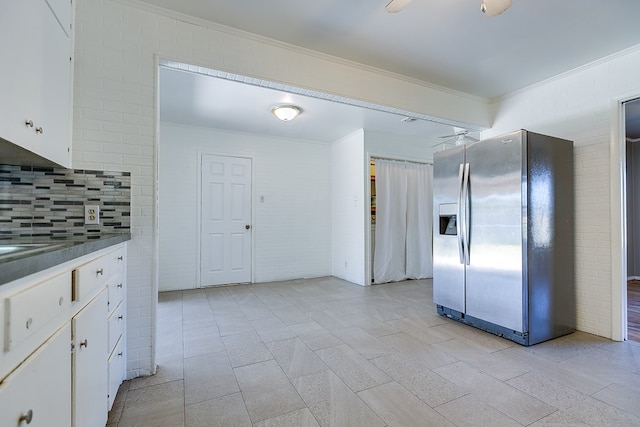 kitchen with brick wall, white cabinets, and stainless steel fridge with ice dispenser