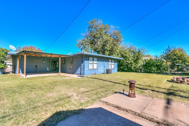 back of property with a patio area, central air condition unit, and a lawn