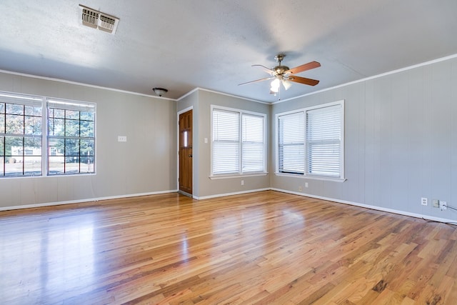 unfurnished room featuring crown molding, ceiling fan, light hardwood / wood-style floors, and a textured ceiling