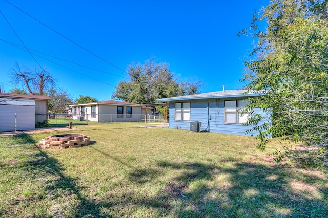 view of yard featuring central AC unit and a fire pit