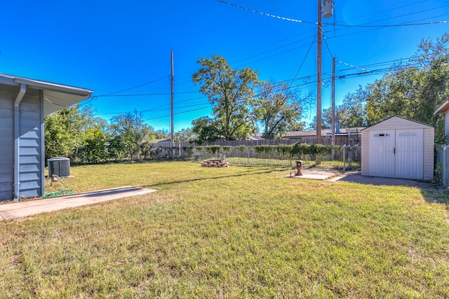 view of yard featuring a storage unit and central AC unit