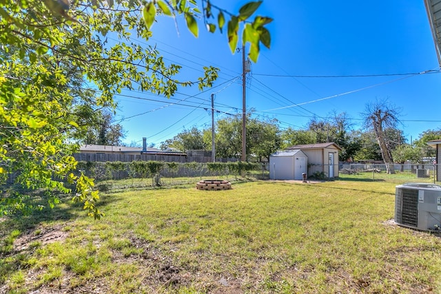 view of yard featuring a storage shed, a fire pit, and central air condition unit