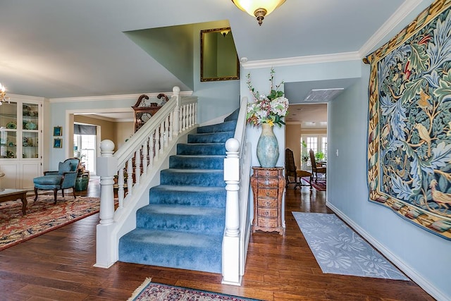stairway with wood finished floors, baseboards, and ornamental molding