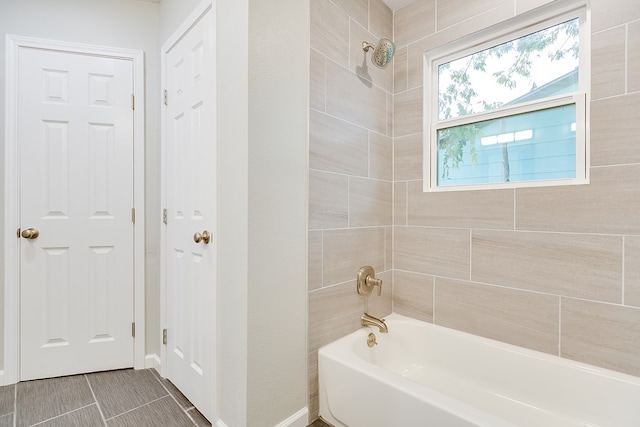 bathroom with tile patterned floors and tiled shower / bath