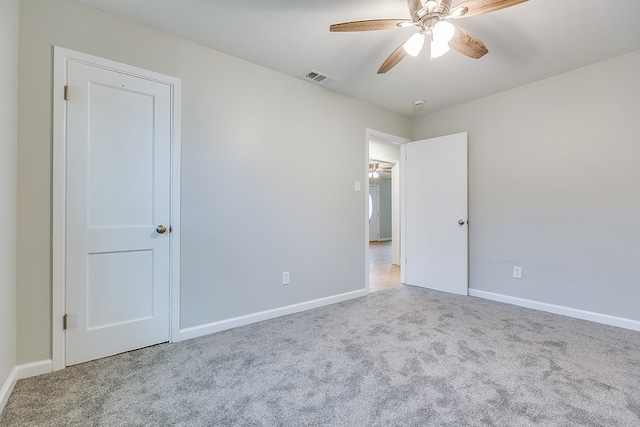 carpeted spare room featuring ceiling fan