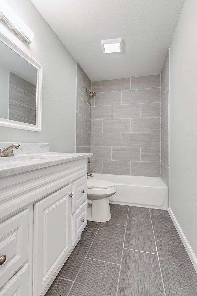 bathroom with vanity, a tile shower, and toilet