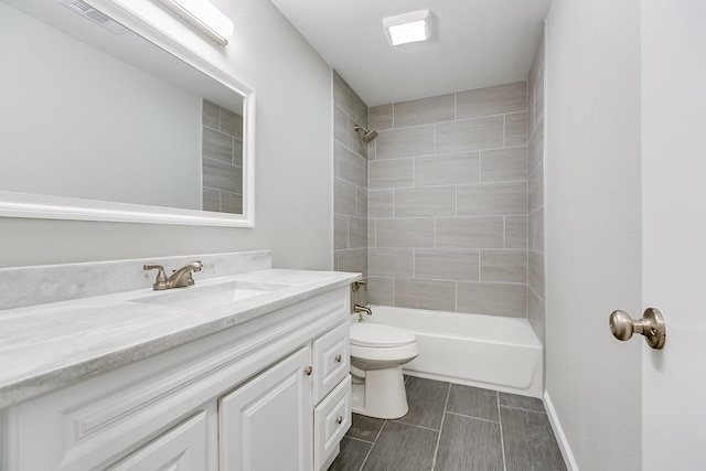 full bathroom featuring tiled shower / bath combo, vanity, and toilet