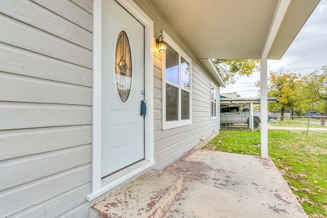 entrance to property with a patio and a lawn