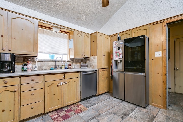 kitchen with light brown cabinets, lofted ceiling, stainless steel appliances, decorative backsplash, and light countertops