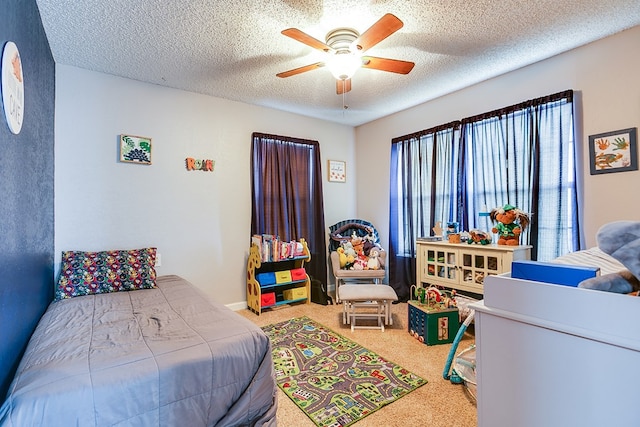 carpeted bedroom featuring baseboards, a textured ceiling, and ceiling fan