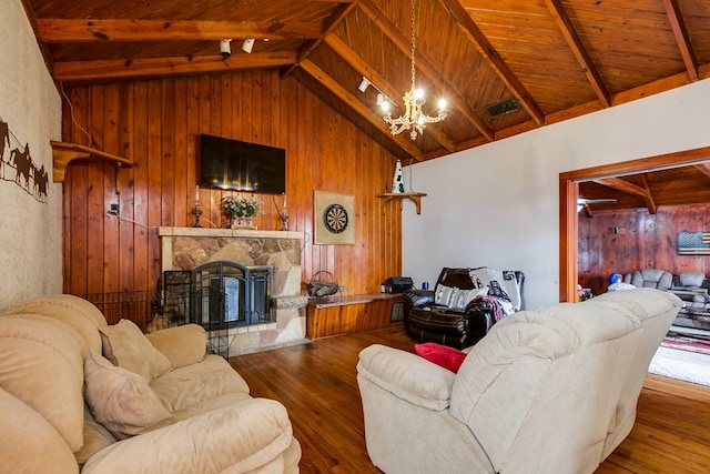 living area with wooden walls, visible vents, an inviting chandelier, wood-type flooring, and wooden ceiling