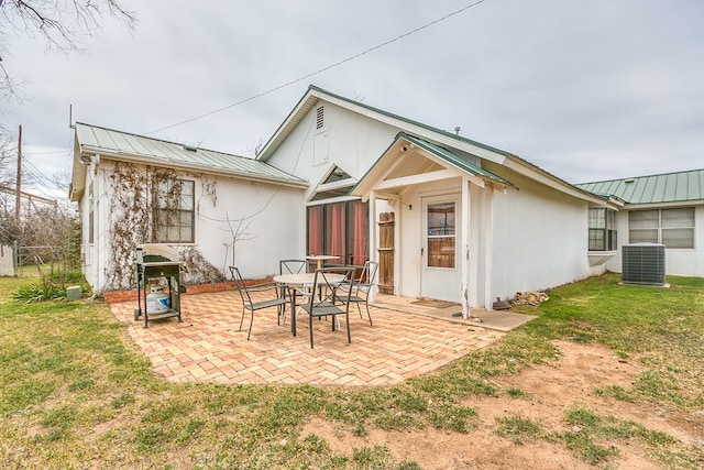 rear view of house featuring a patio, central air condition unit, a yard, and metal roof