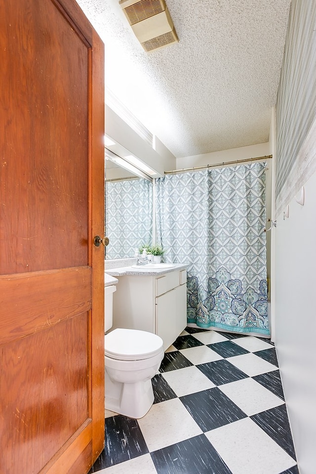 bathroom with tile patterned floors, visible vents, toilet, a textured ceiling, and vanity